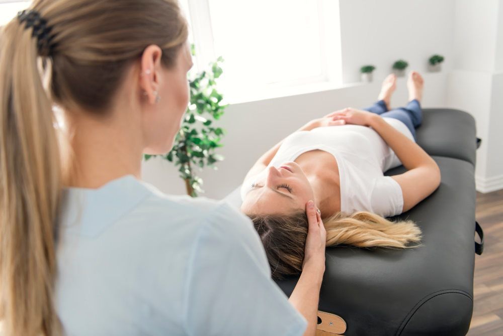 Therapist Massaging Clients Head - Physiotherapist in Mountain Creek, QLD