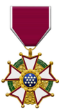 Medal with a maroon and white ribbon; gold, green, and blue star-shaped emblem.