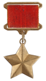 Gold star-shaped medal with a red ribbon and gold attachment.