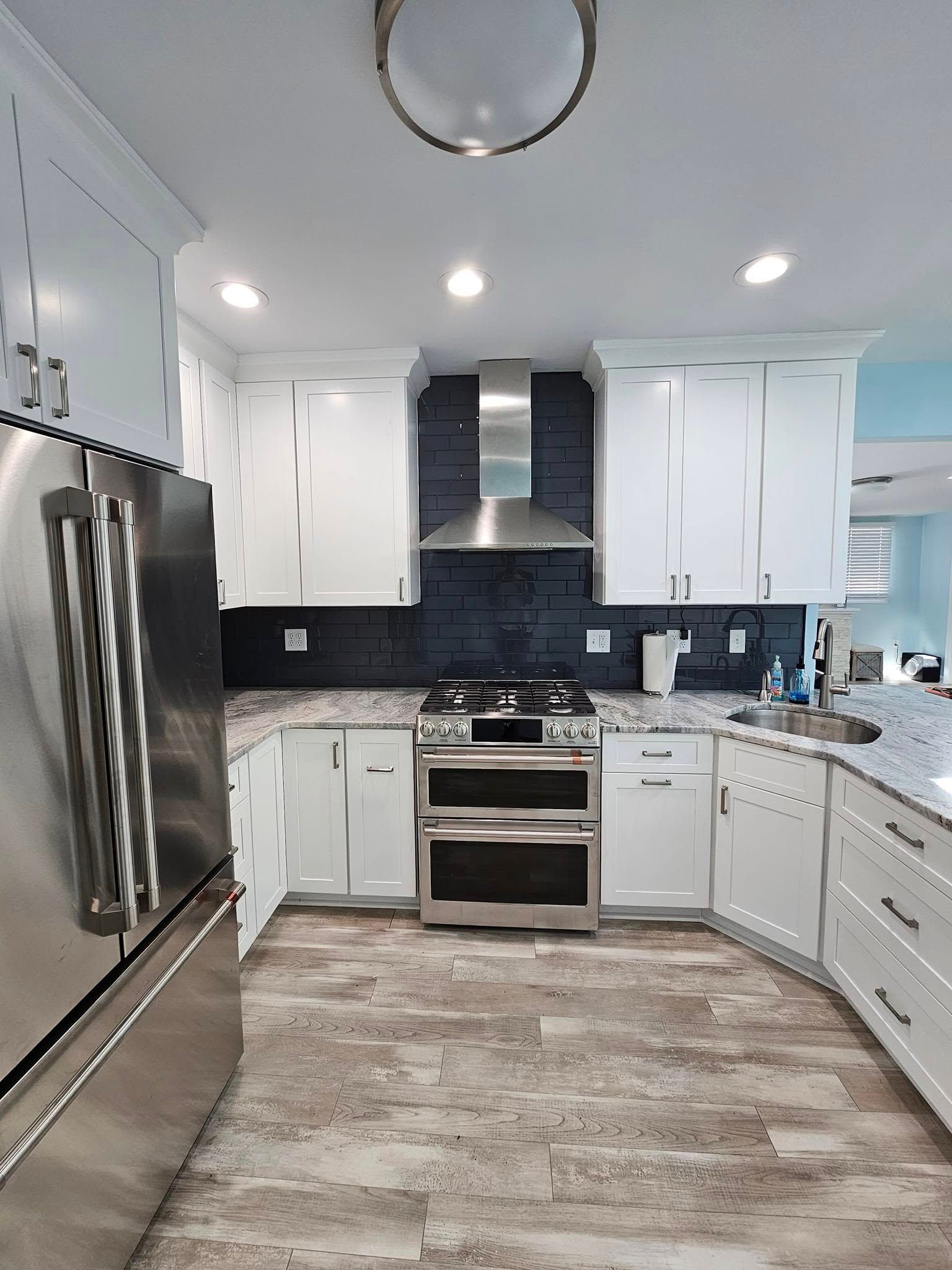 A kitchen with white cabinets and stainless steel appliances