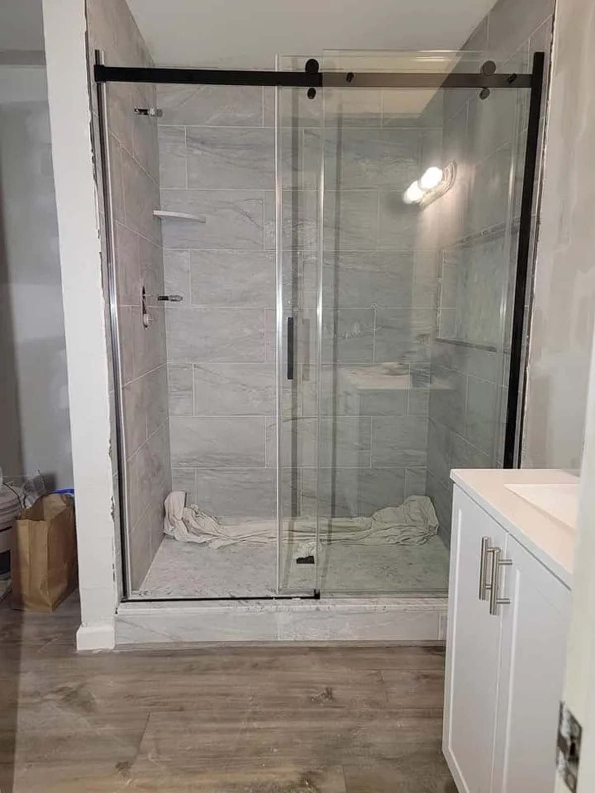 A bathroom with a sliding glass shower door and a sink.