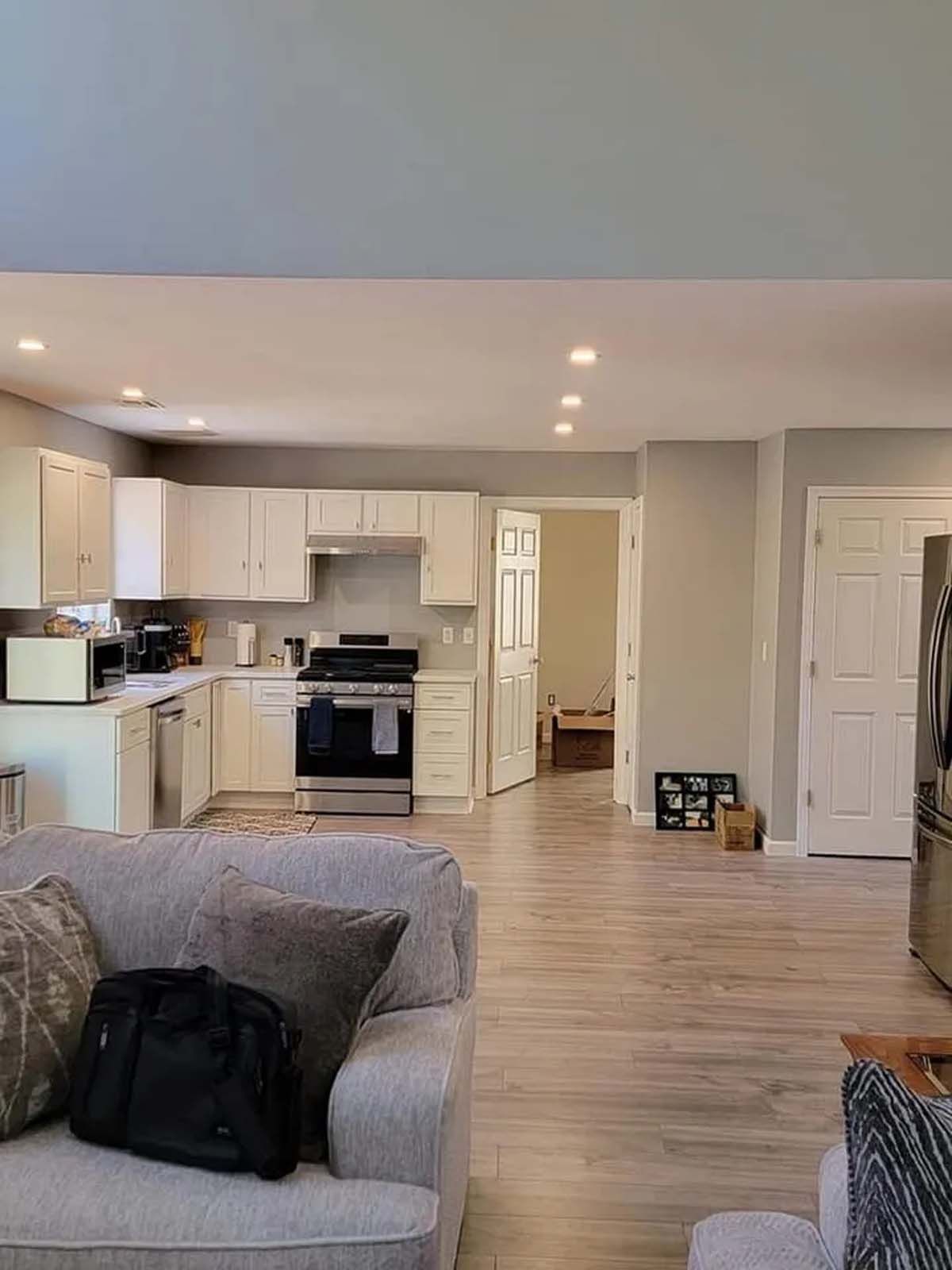 A living room with a couch , chair , and kitchen.