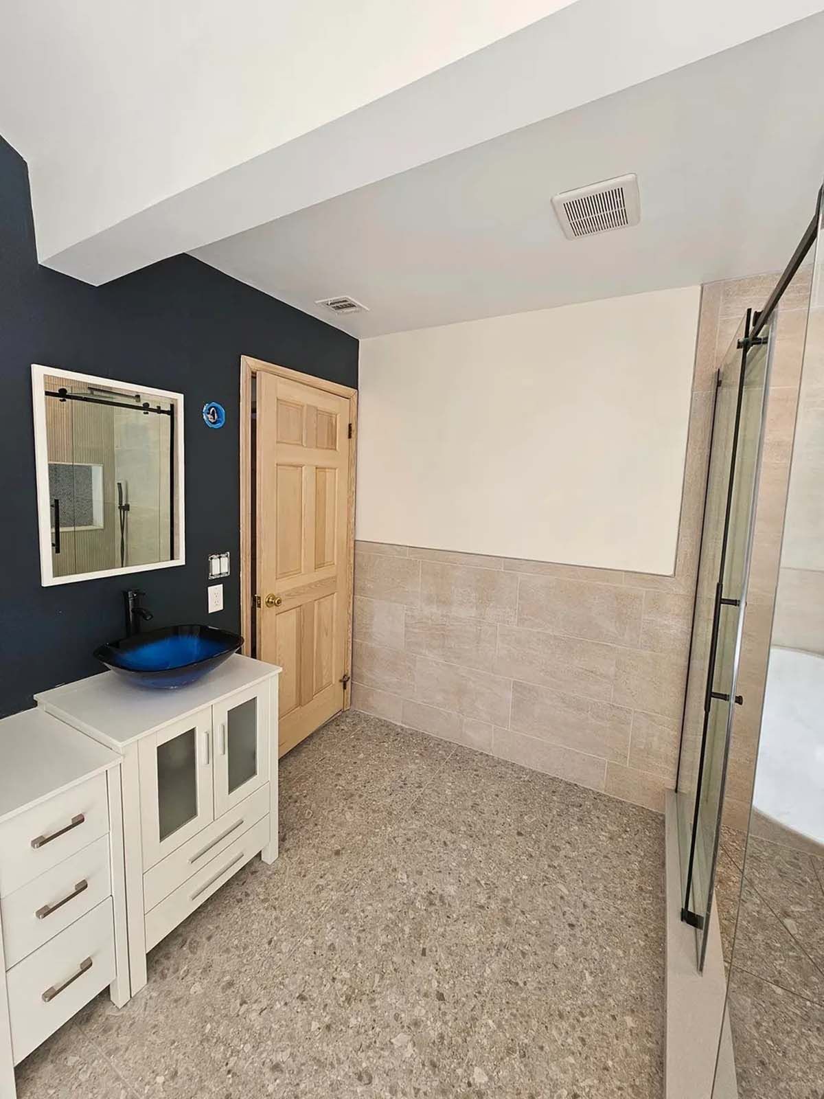 A bathroom with a sink , mirror , and shower.