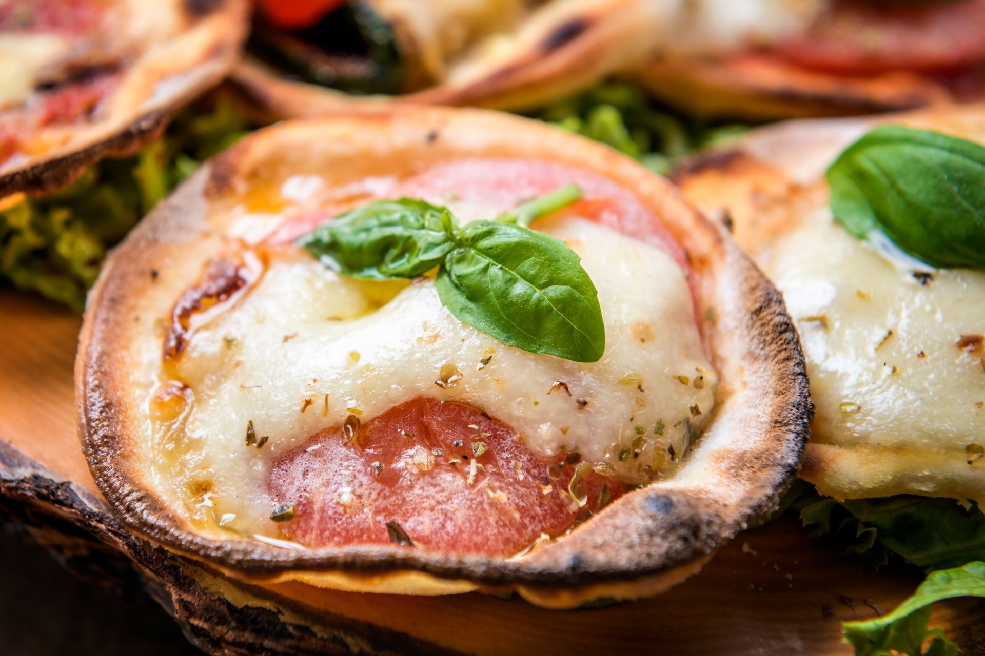 una pizza su un piatto bianco su un tavolo di legno.