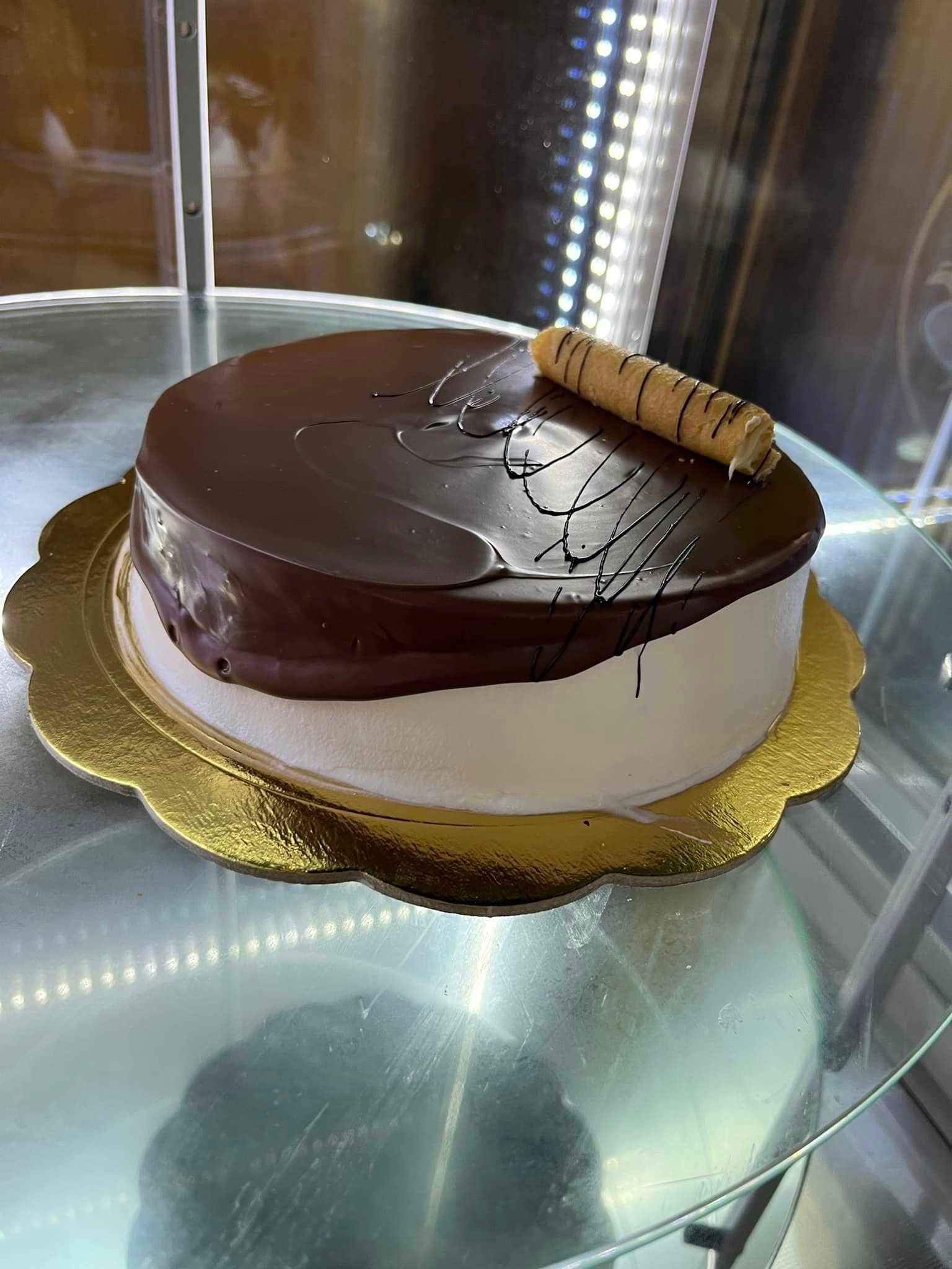 una torta è posata sopra una teca di vetro.