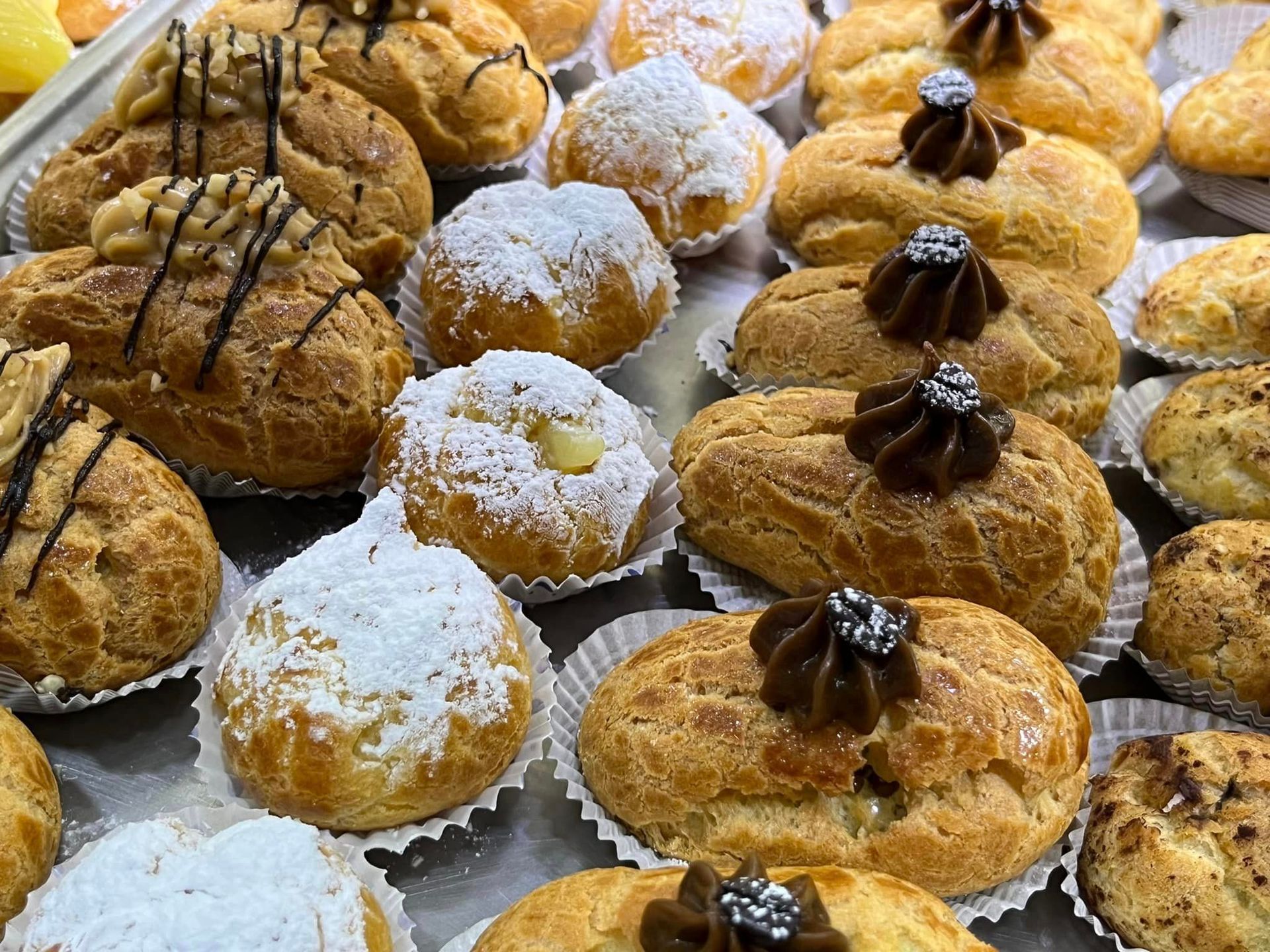 su un tavolo sono seduti una varietà di pasticcini con zucchero a velo sopra.
