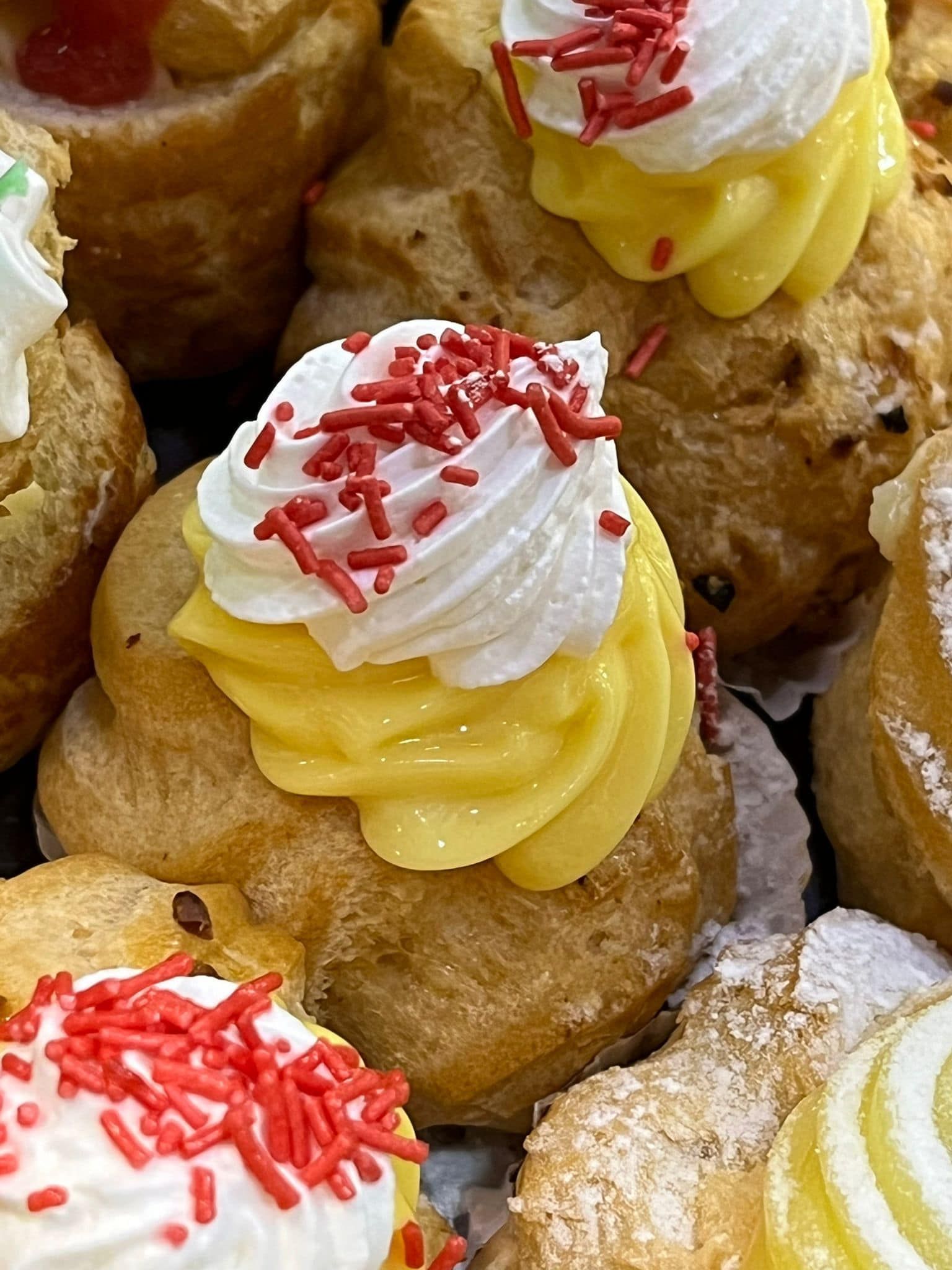 un primo piano di un cupcake con glassa gialla e granelli rossi