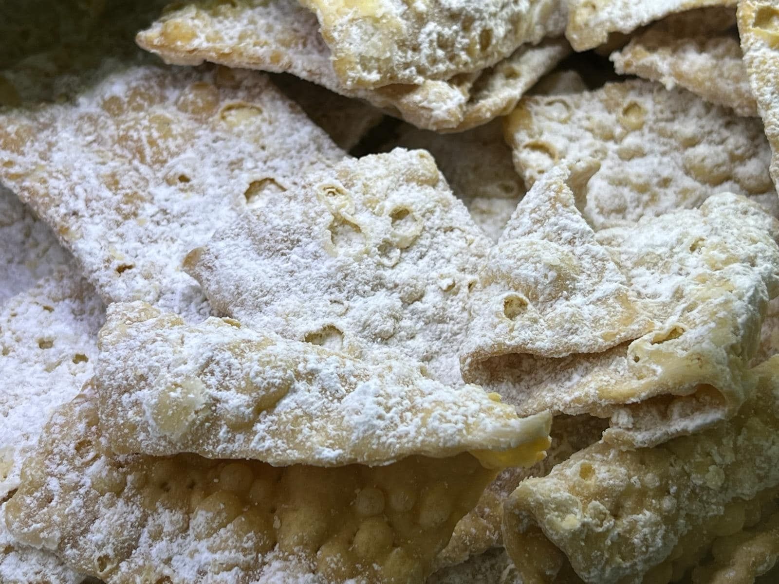 un primo piano di una pila di cibo con sopra zucchero a velo.