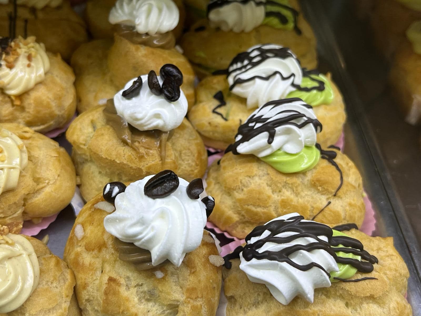 un mucchio di cupcakes ricoperti di glassa è seduto su un tavolo.
