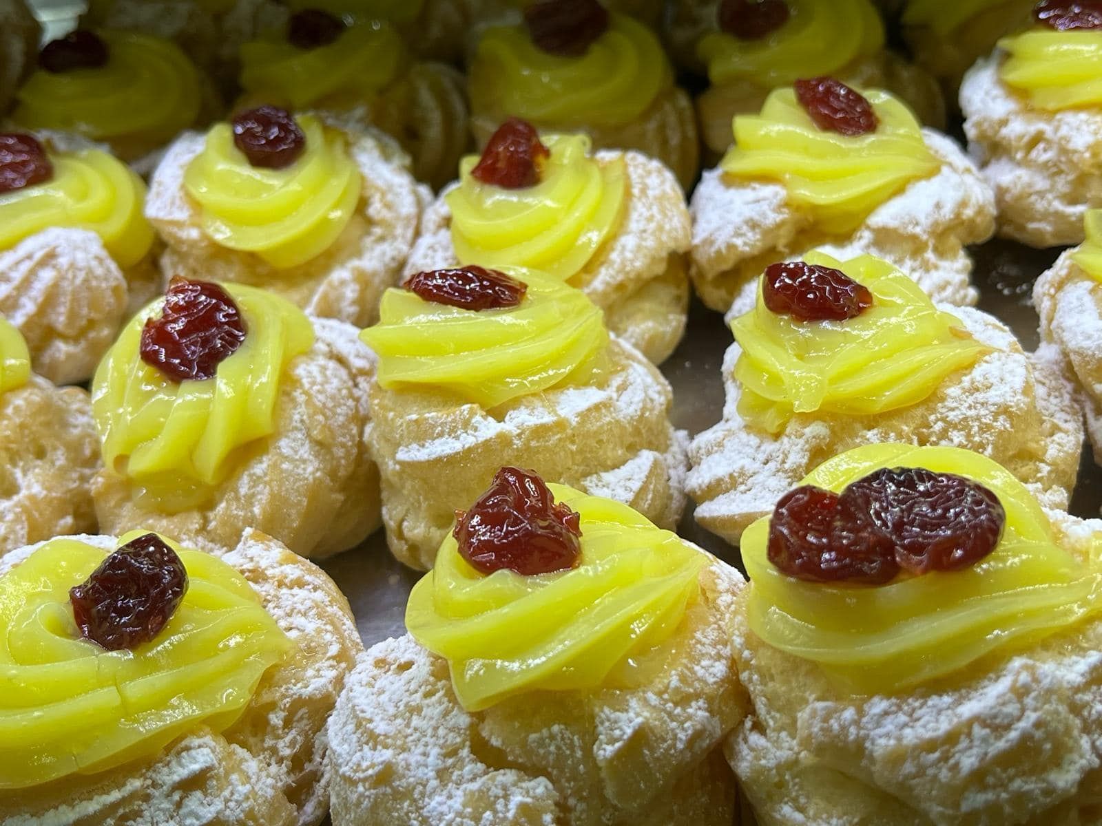 un mucchio di cupcakes con glassa gialla e zucchero a velo sopra.