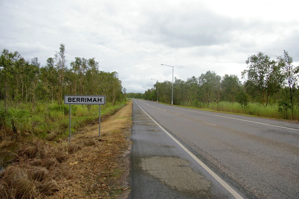 Road Sign and a Straight Road, With Trees and Cloudy Sky — Quack Pest Control in Berrimah, NT