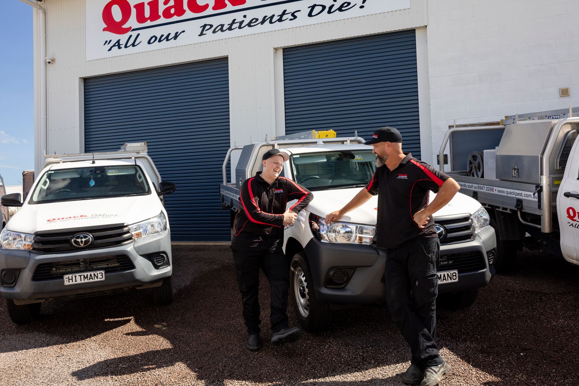 Two Men Laughing Whilst Leaning On Car  — Quack Pest Control in Humpty Doo, NT