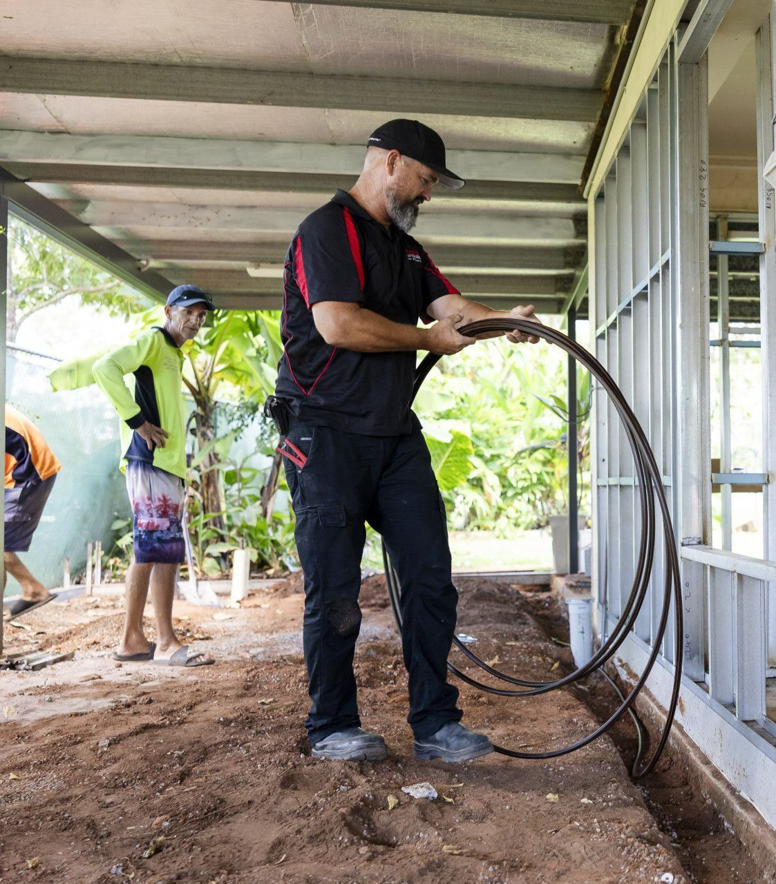 A Man Installing Piping Around House— Quack Pest Control in Winnellie, NT