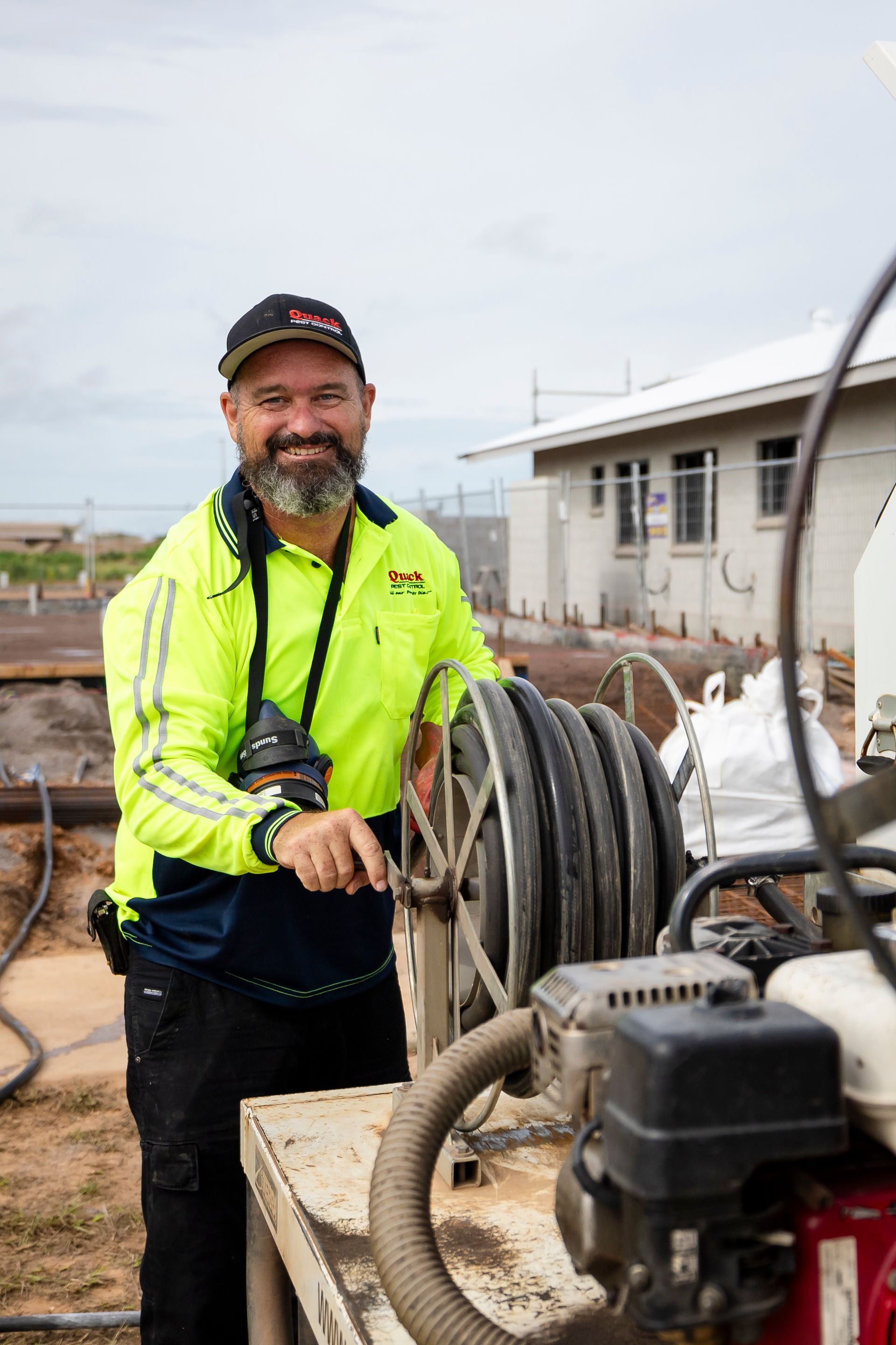 A Man Smiling at The Camera Whilst Winding Pipe — Quack Pest Control in Winnellie, NT