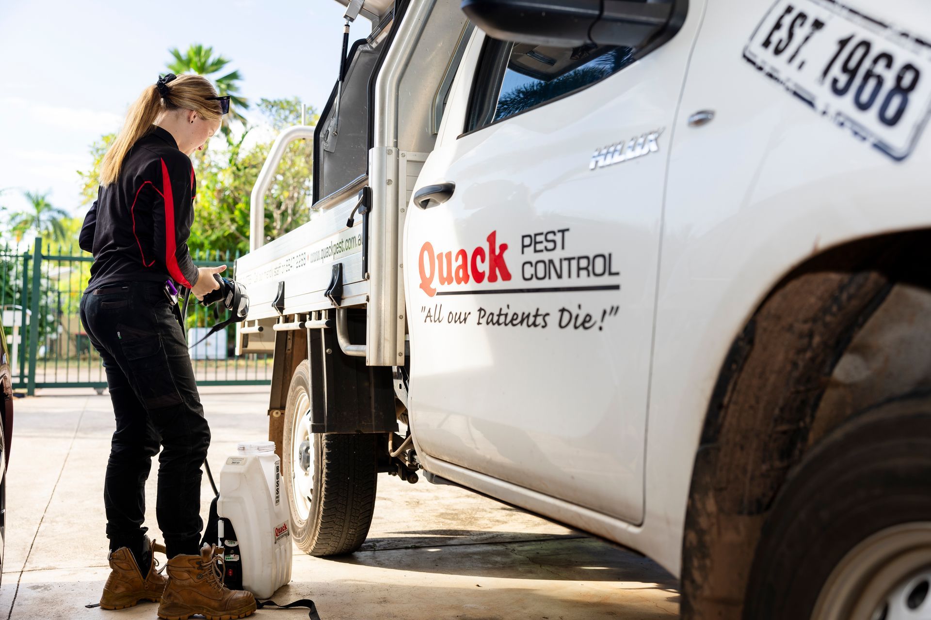 Woman Prepares Pest Control Equipment by a Truck — Quack Pest Control in Casuarina, NT