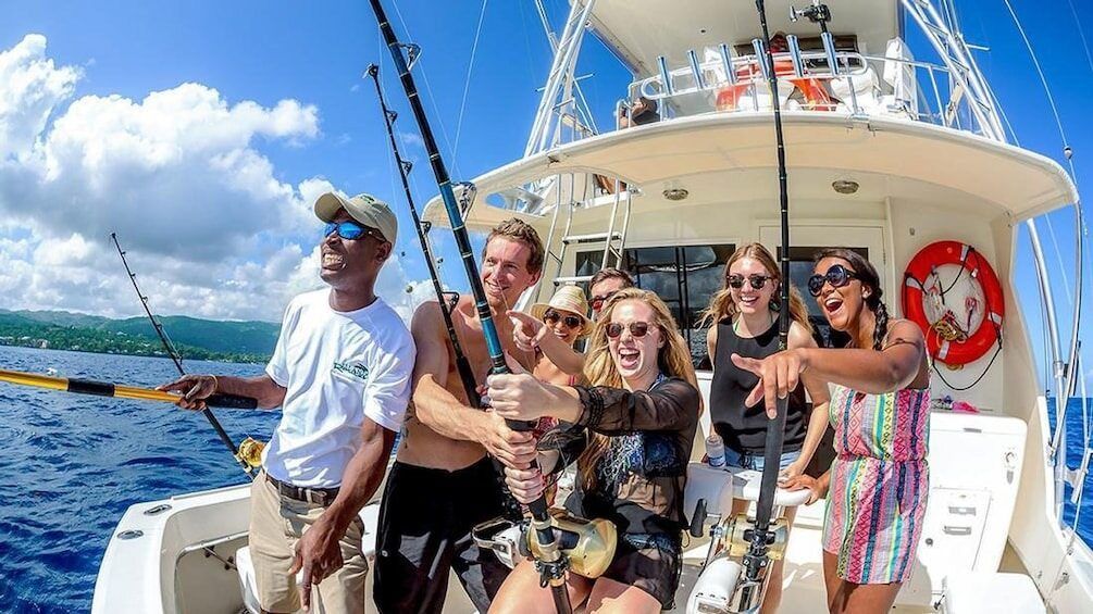 A group of people are fishing on a boat in the ocean.