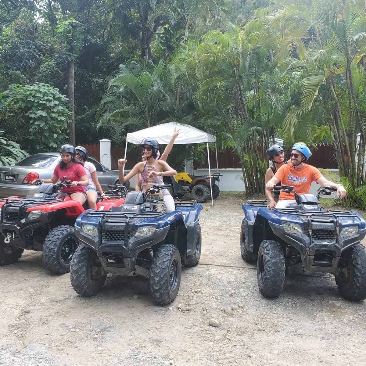 A group of people are riding atvs in a parking lot
