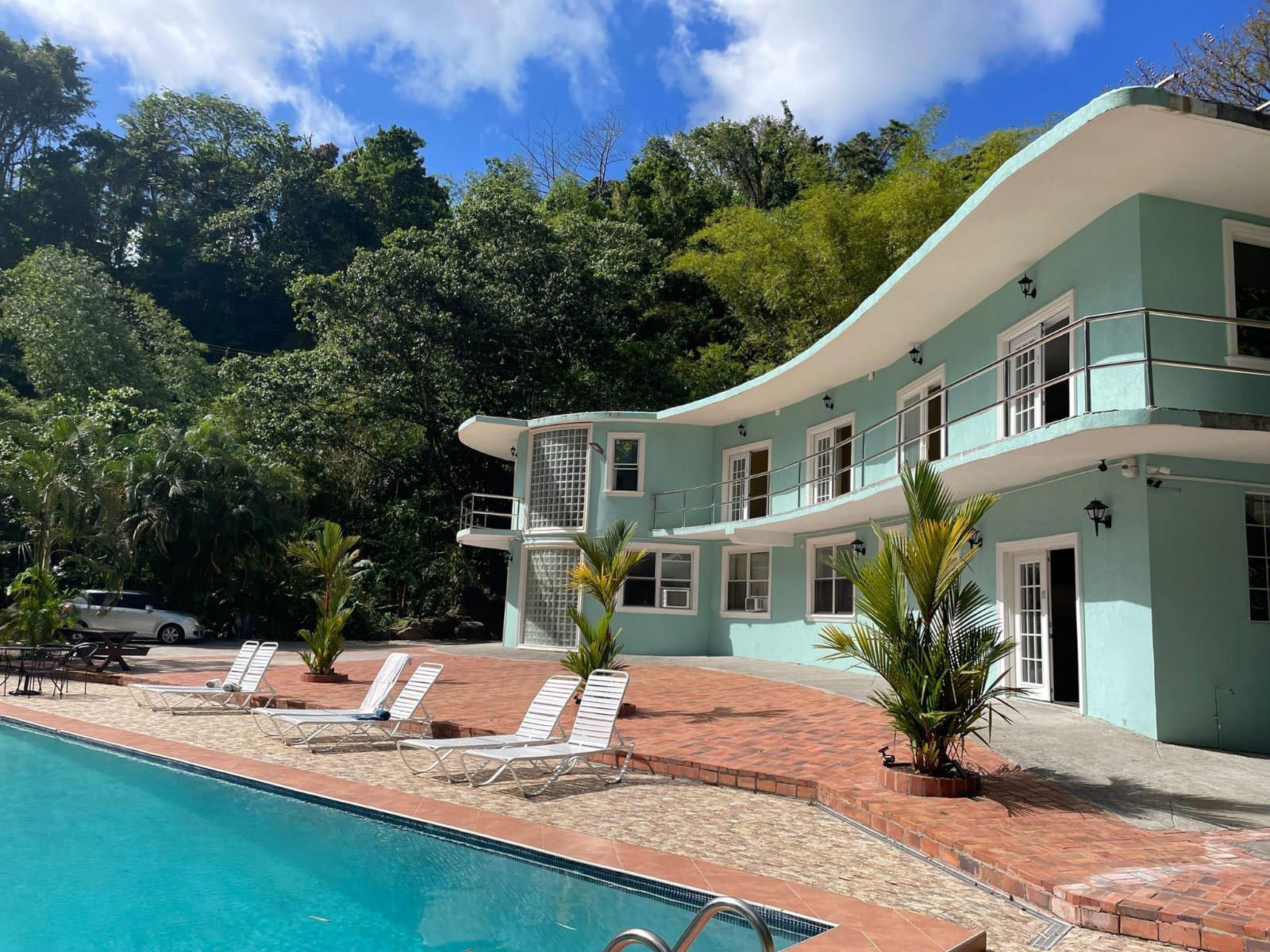A large house with a swimming pool in front of it