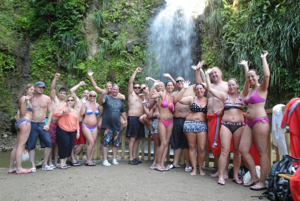 A group of people posing for a picture in front of a waterfall