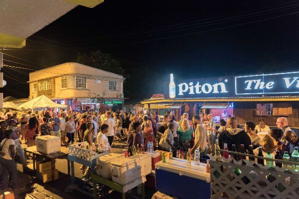 A crowd of people are gathered in front of a building that says piton the vine.