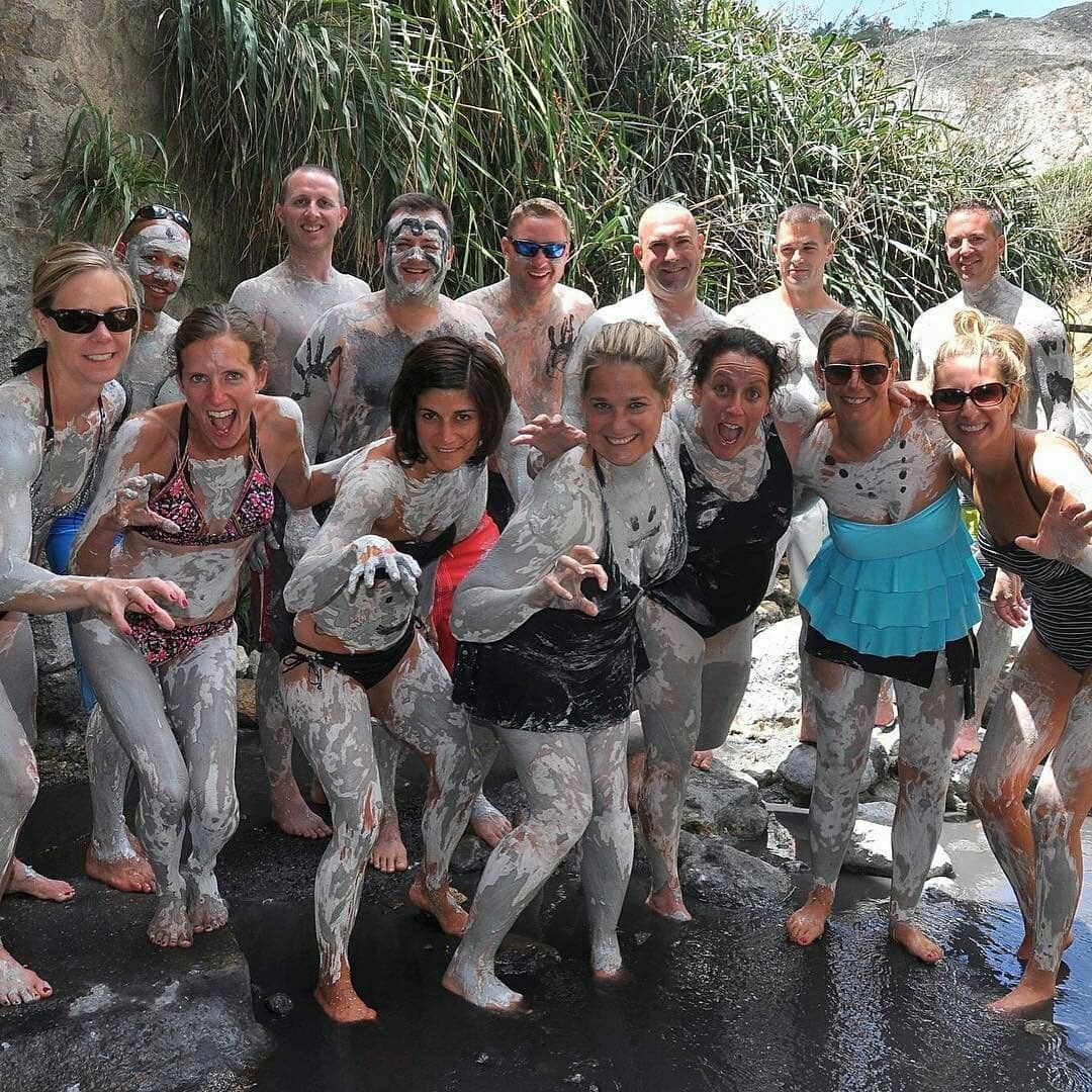 A group of people are covered in mud and posing for a picture