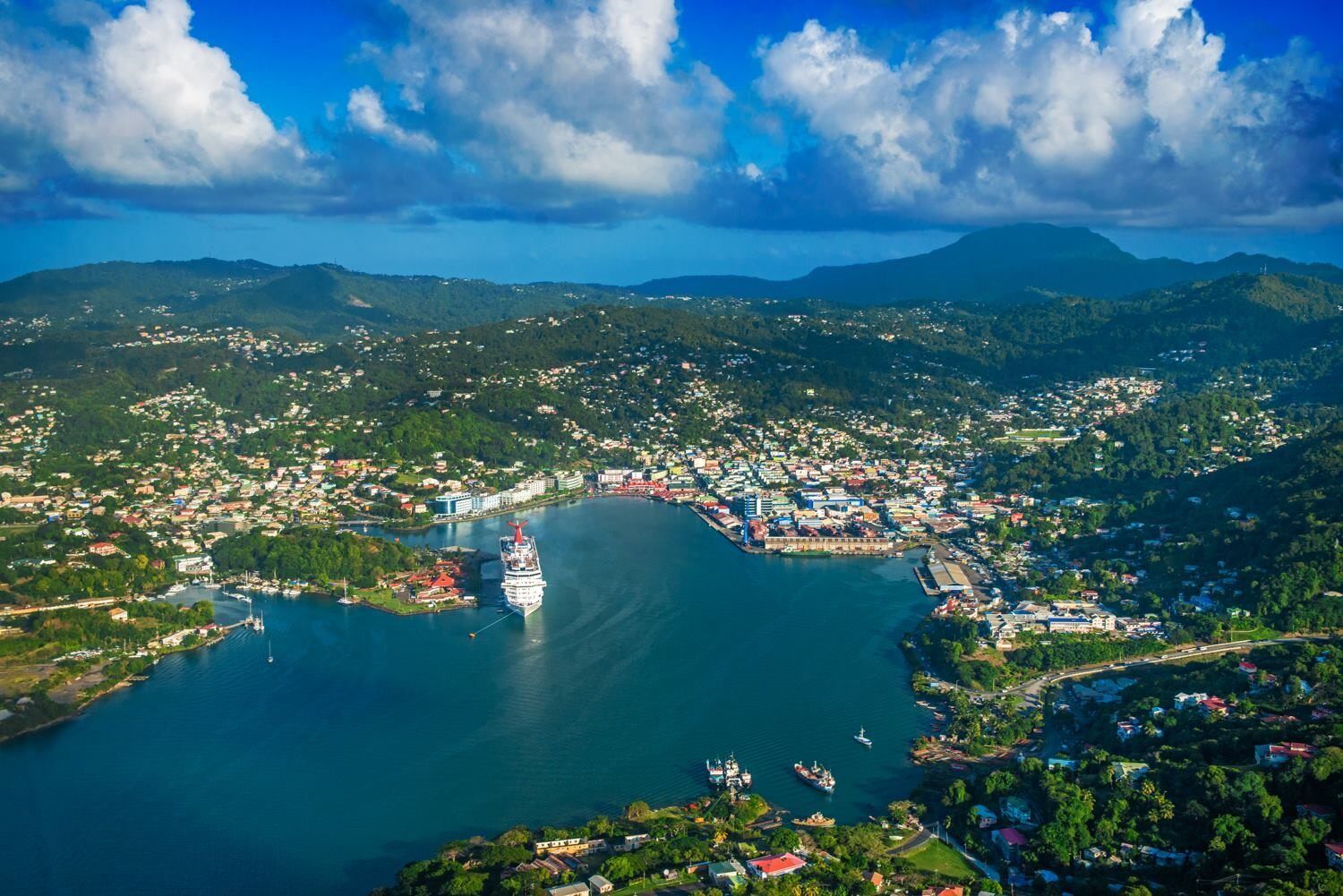 An aerial view of a large body of water surrounded by mountains and a city.
