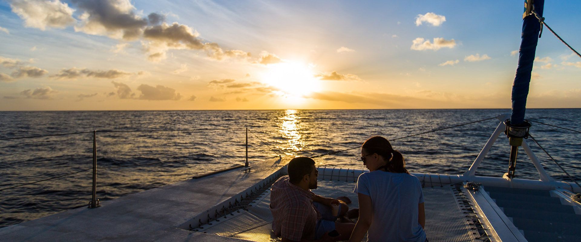 Two people on a boat at sunset.