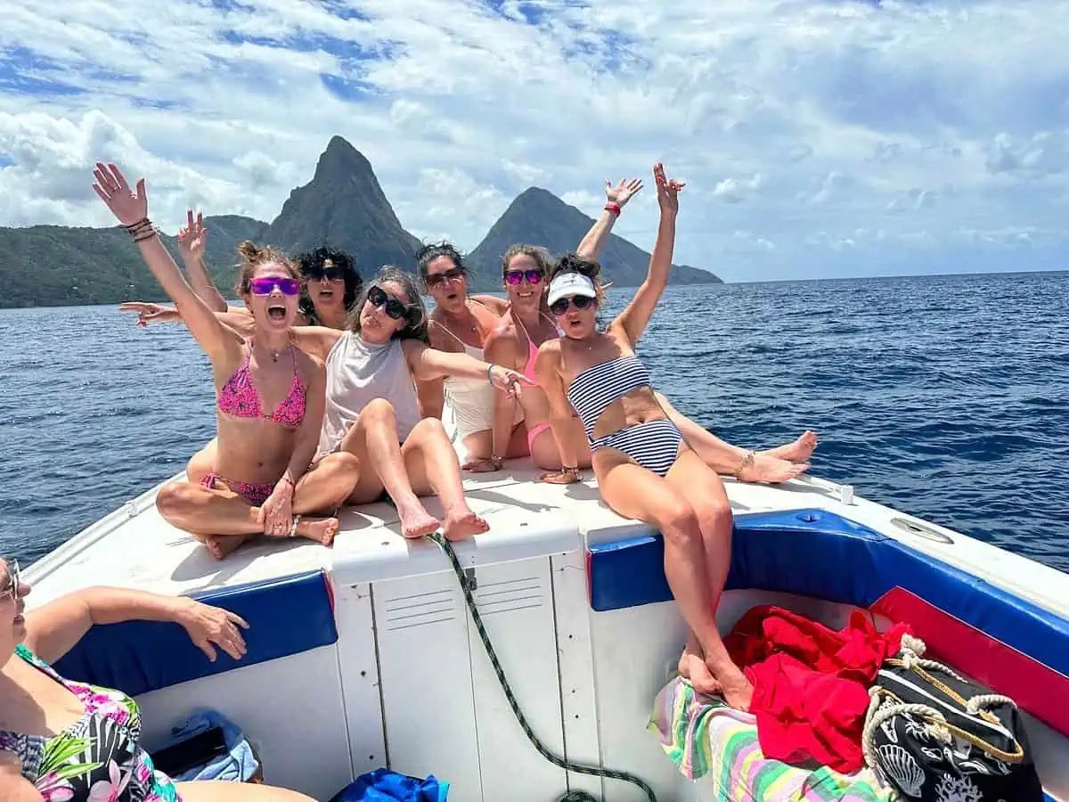 A group of women are sitting on the back of a boat in the ocean.