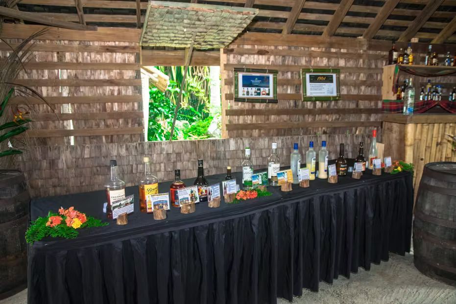 A long table with bottles of alcohol on it in a room.