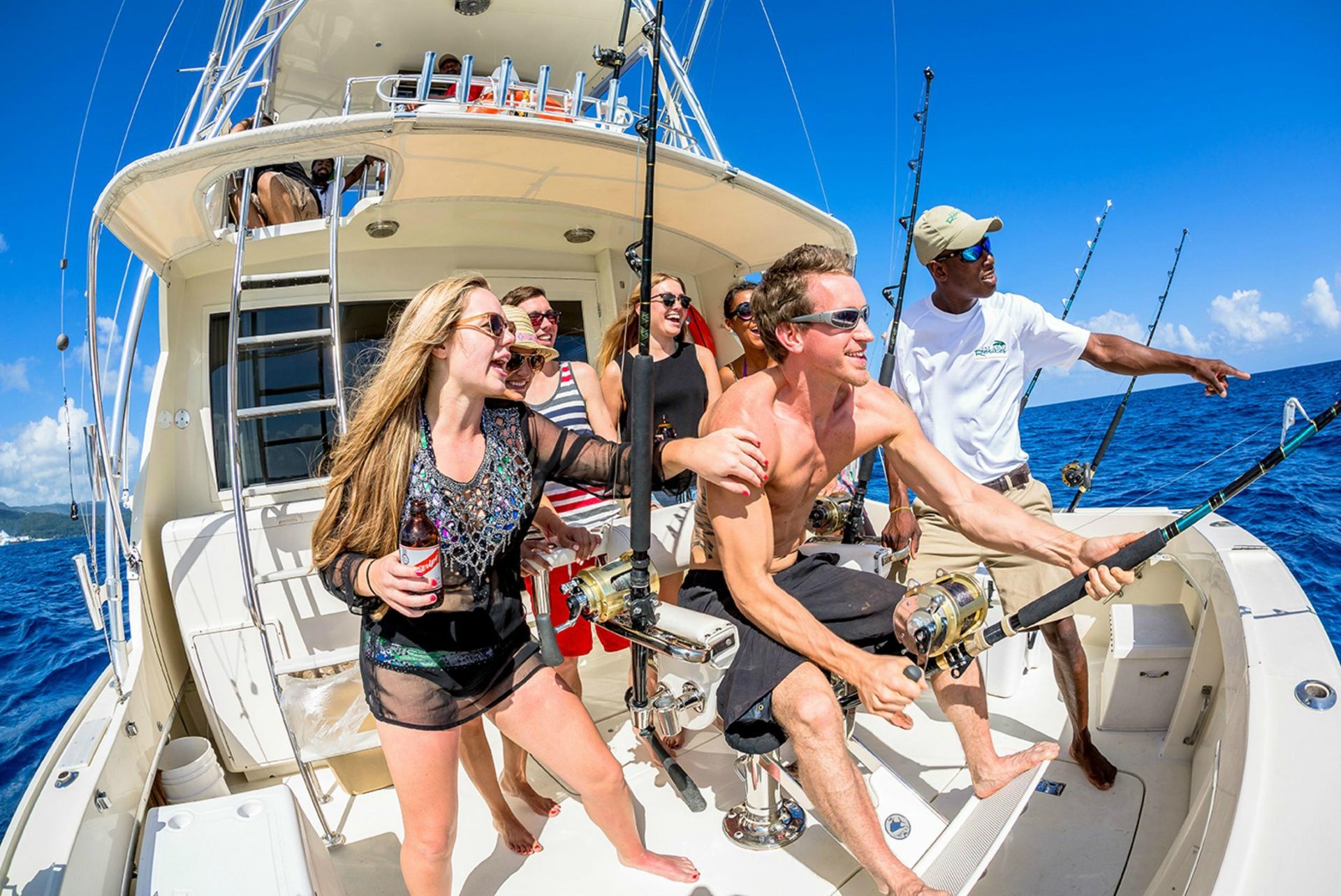 A group of people are fishing on a boat in the ocean.