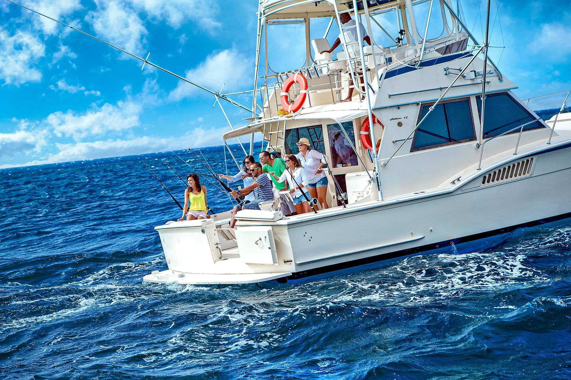 A group of people are fishing on a boat in the ocean.