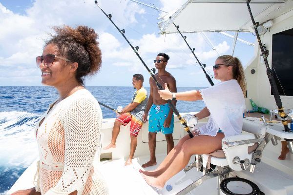 A group of people are fishing on a boat in the ocean.