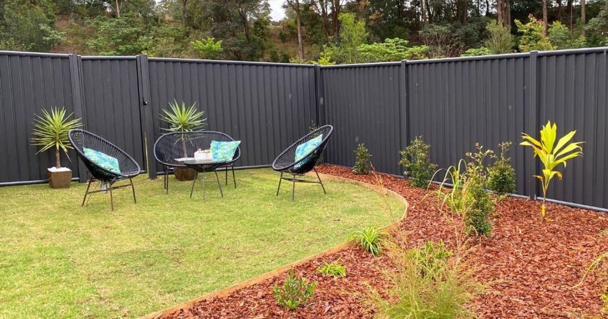 A Backyard with A Fence , Chairs , a Table and A Bench — Byron & Beyond Fencing In Billinudgel, NSW
