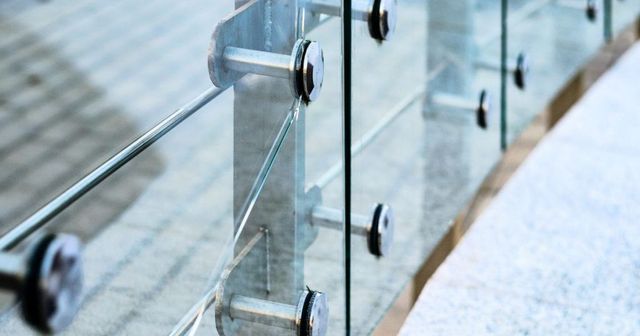 A Close up Of a Semi Frameless Glass Railing on A Staircase — Byron & Beyond Fencing In Billinudgel, NSW