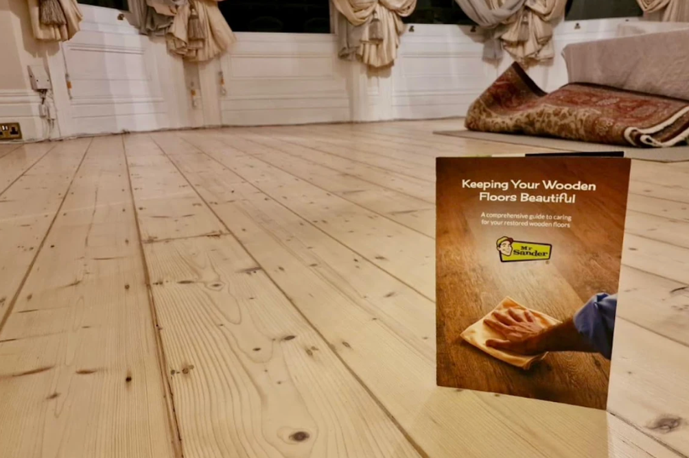 Brochure on wood floor cleaning, in front of a wood floor.