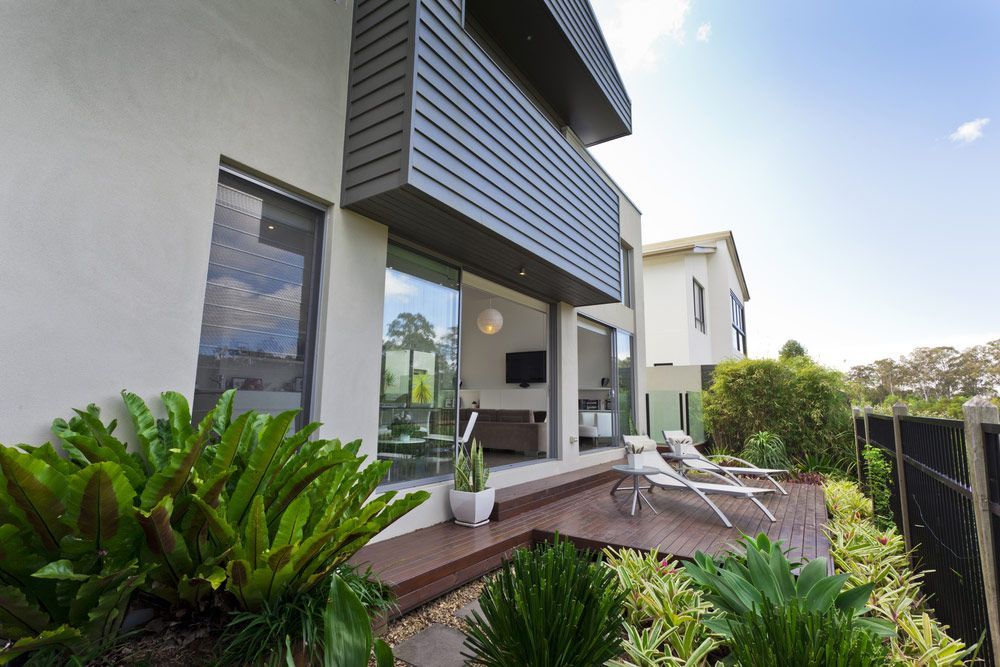 Modern House Facade With Wooden Pation And Bi Fold Window — Glass Repairs & Installations in Quirindi, NSW