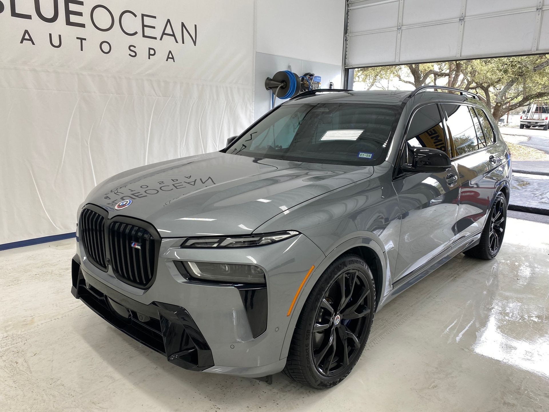 A grey bmw x5 m is parked in a garage.