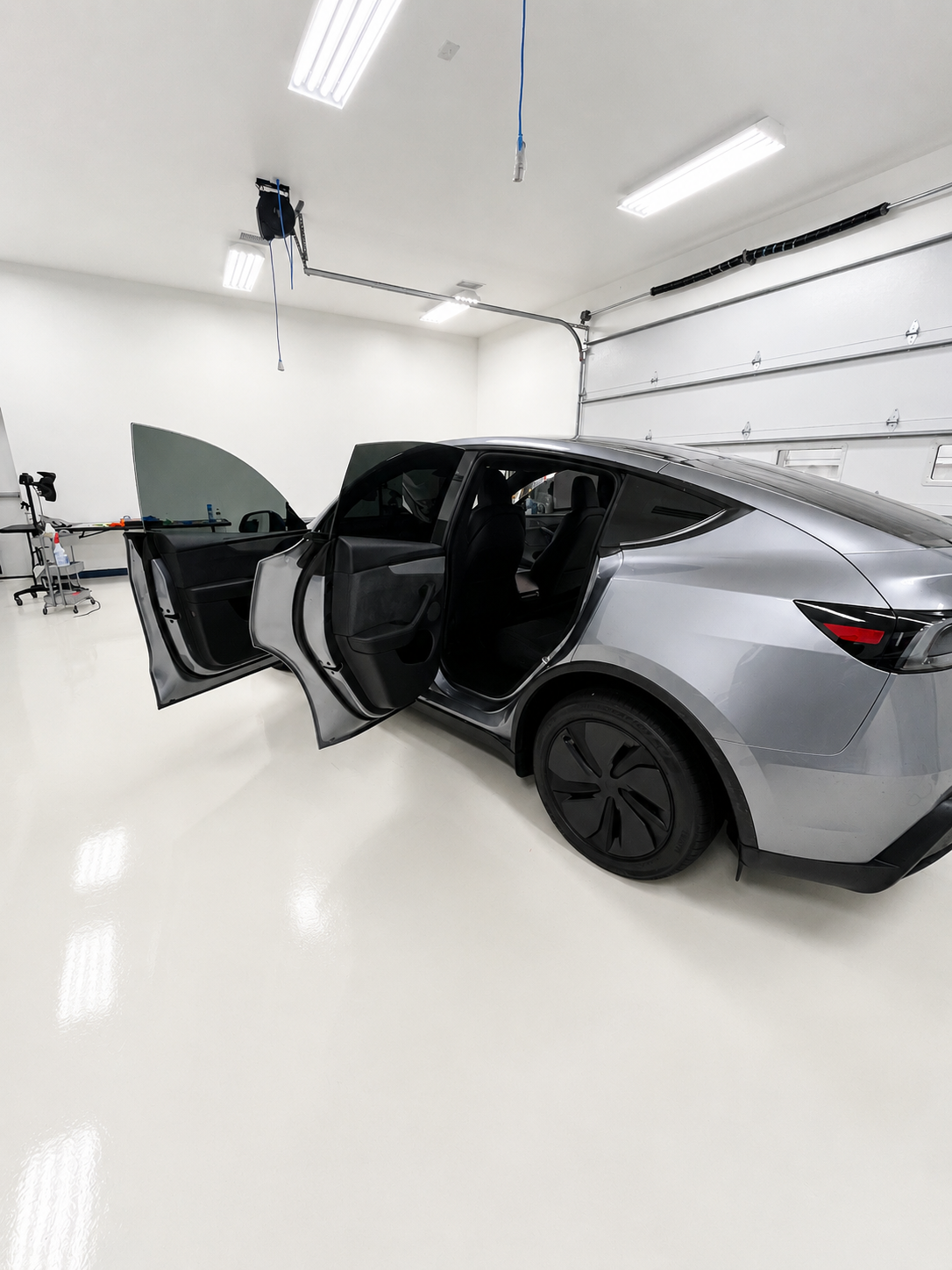 2026 Tesla Model Y with doors open showing that the side windows are now tinted