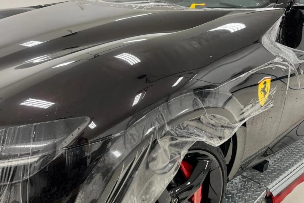 A close-up of a luxury Ferrari being fitted with paint protection film by Blue Ocean Auto Spa, showcasing precision alignment and glossy finish.