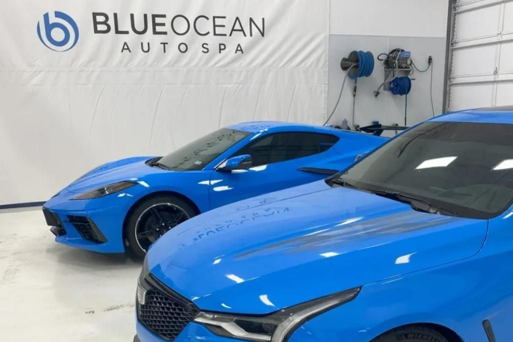 Two bright blue cars parked inside the Blue Ocean Auto Spa detailing bay, showcasing the company’s clean and professional workspace.
