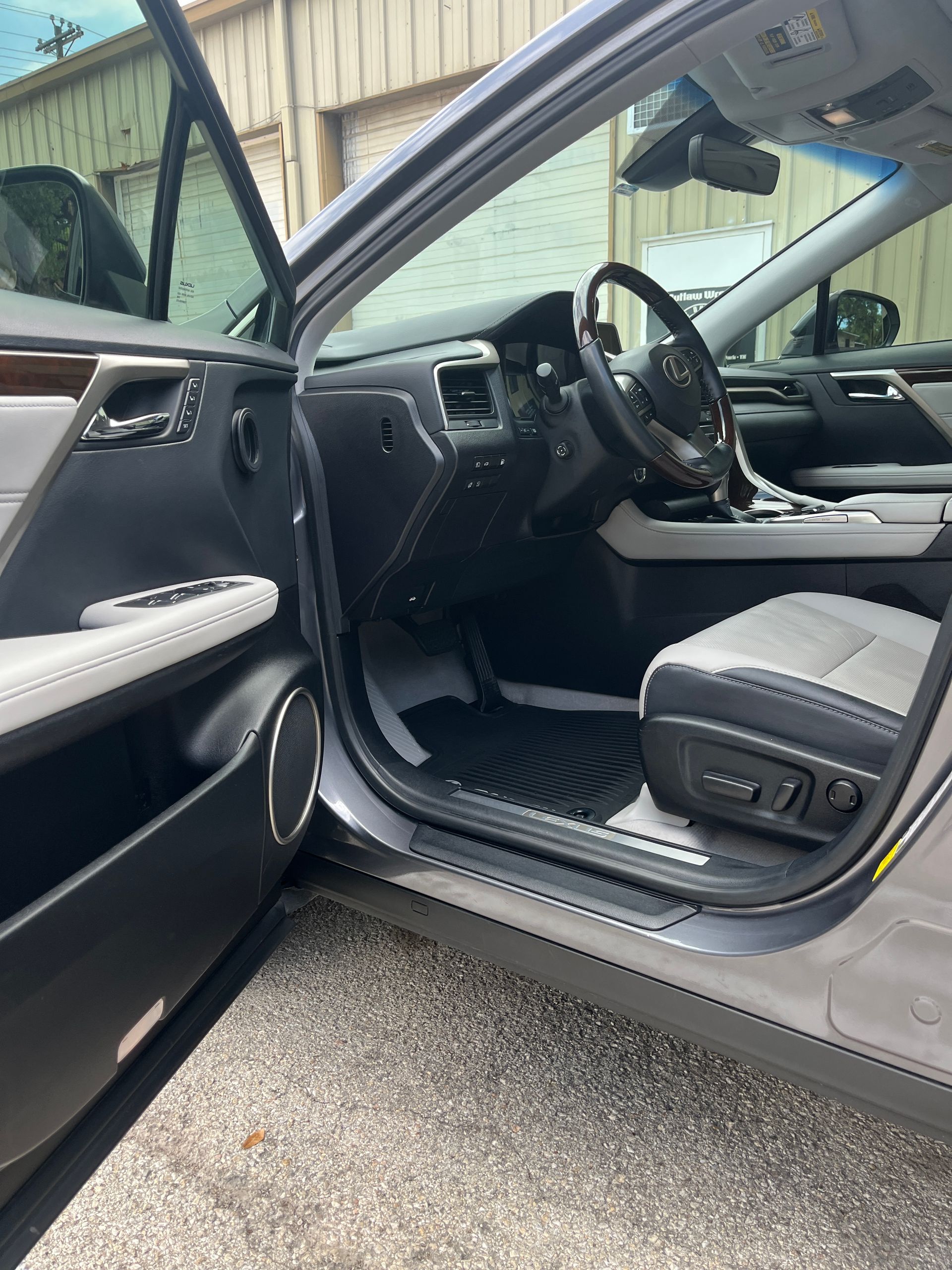 A close up shows window tint film being pressed onto a wet car window as water beads across the glass surface. A hand works from the inside edg e to secure the tint and remove trapped moisture.