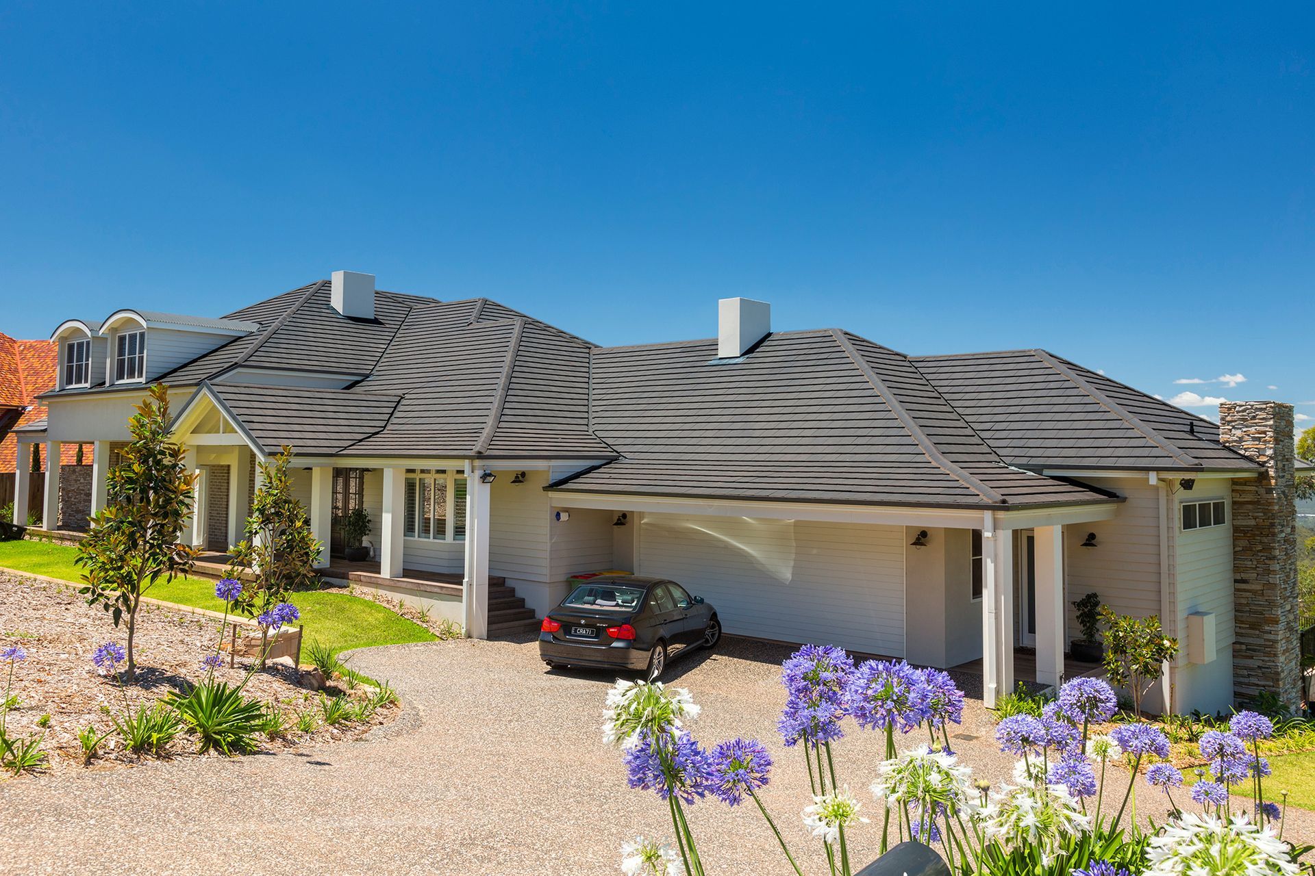 A Car is Parked in Front of a Large House — Mr Roof Tiles in Northern Rivers, NSW