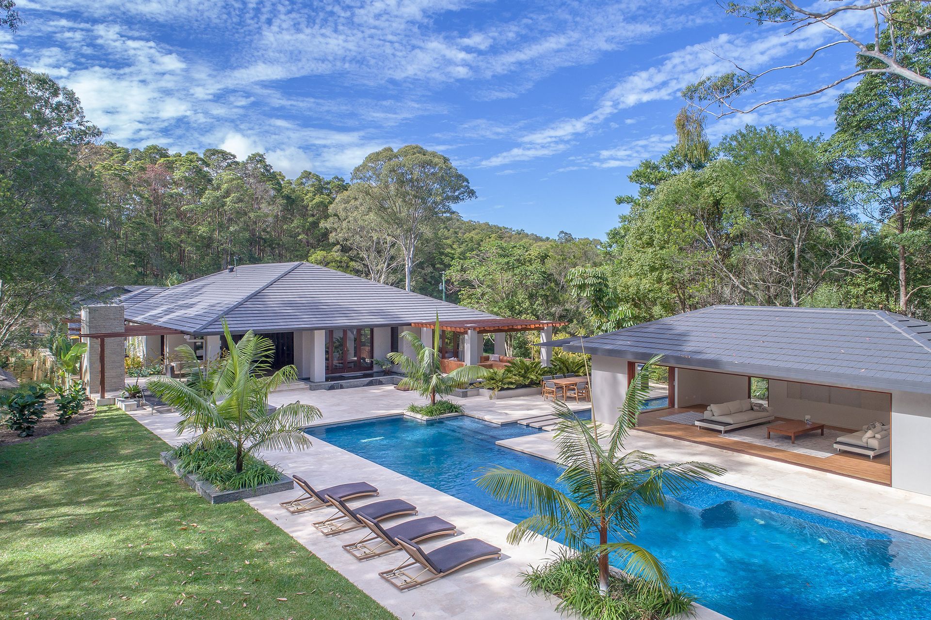 An Aerial View of a House With a Large Swimming Pool Surrounded by Trees — Mr. Roof Tiles in Ballina, NSW