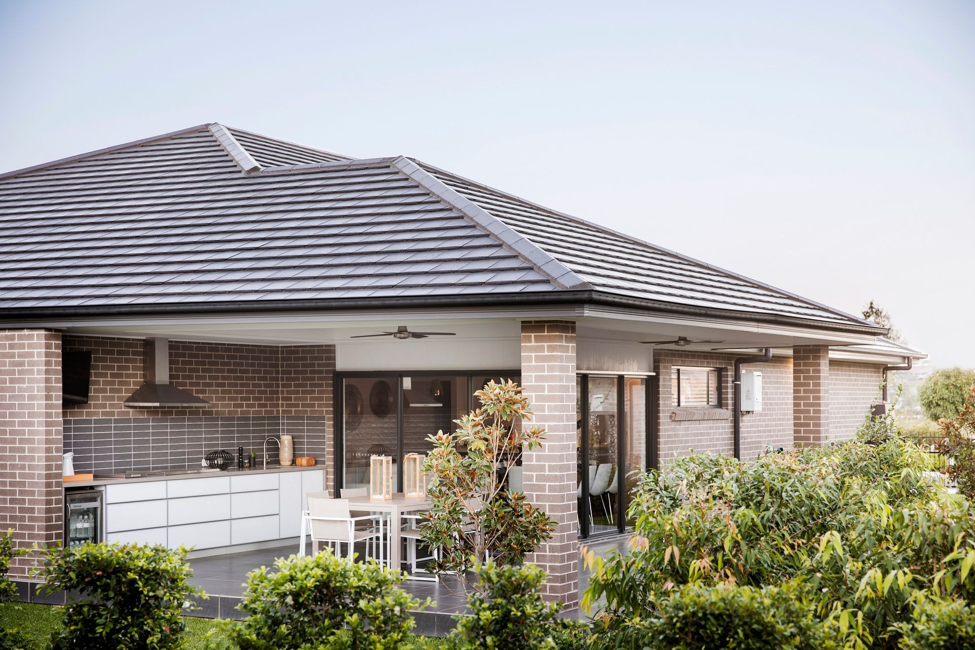 A Brick House With a Slate Roof and a Large Porch Surrounded by Trees — Mr Roof Tiles in Kingscliff, NSW