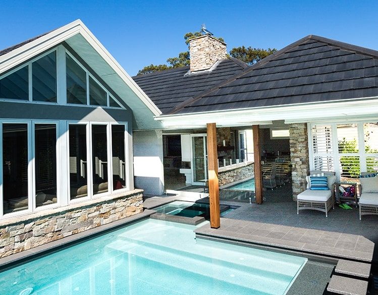 A Large House With a Swimming Pool in Front of It — Mr Roof Tiles in Kingscliff, NSW