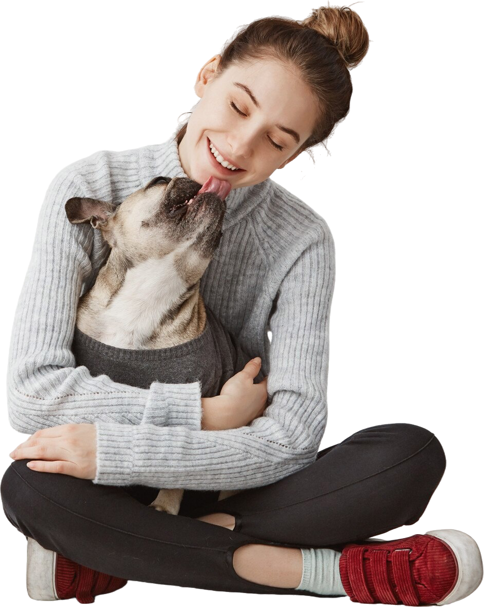 A woman is sitting on the floor holding a dog.