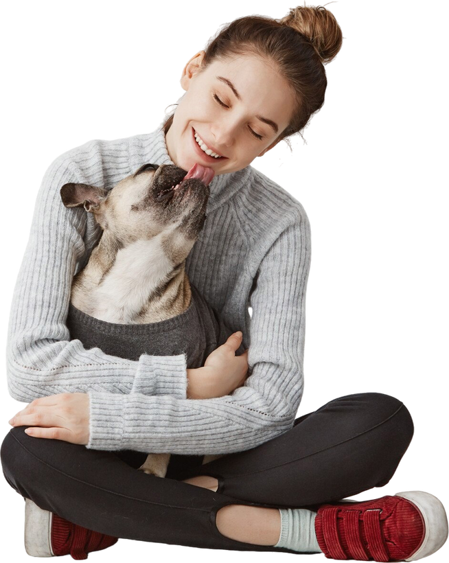 A woman is sitting on the floor holding a dog.