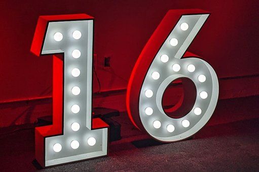 The number 16 is lit up with lights on a red background.