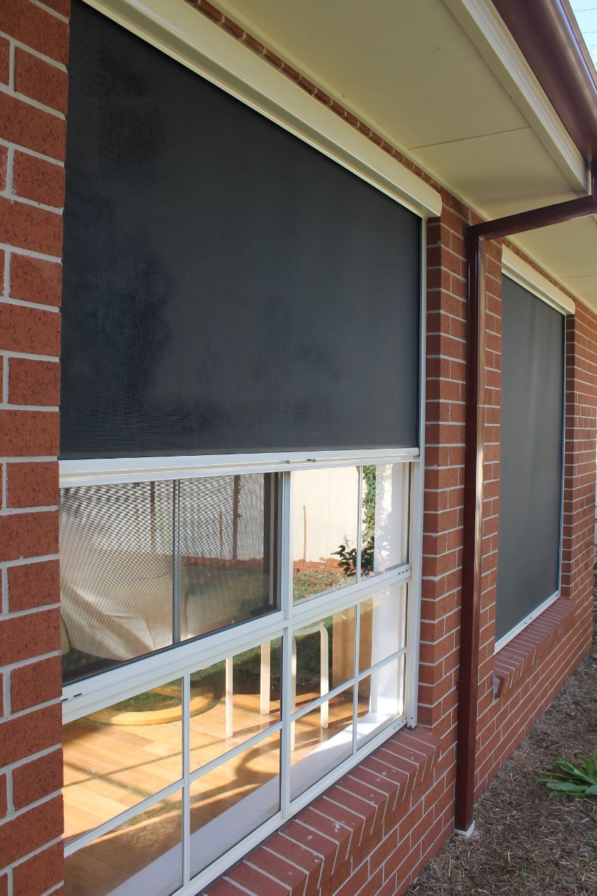 A Brick Building With a Window With a Screen on It — South Burnett Garage Doors In Nanango, QLD