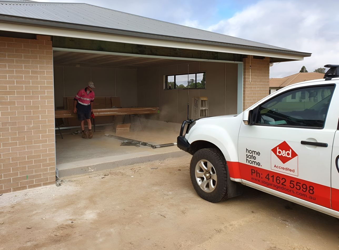 A White Truck is Parked in Front of a Brick Building — South Burnett Garage Doors In Kingaroy, QLD